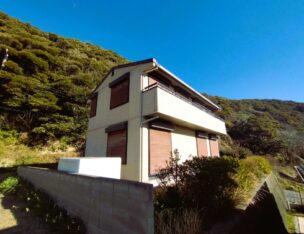 北側は山、南側に開けた高台に建つ